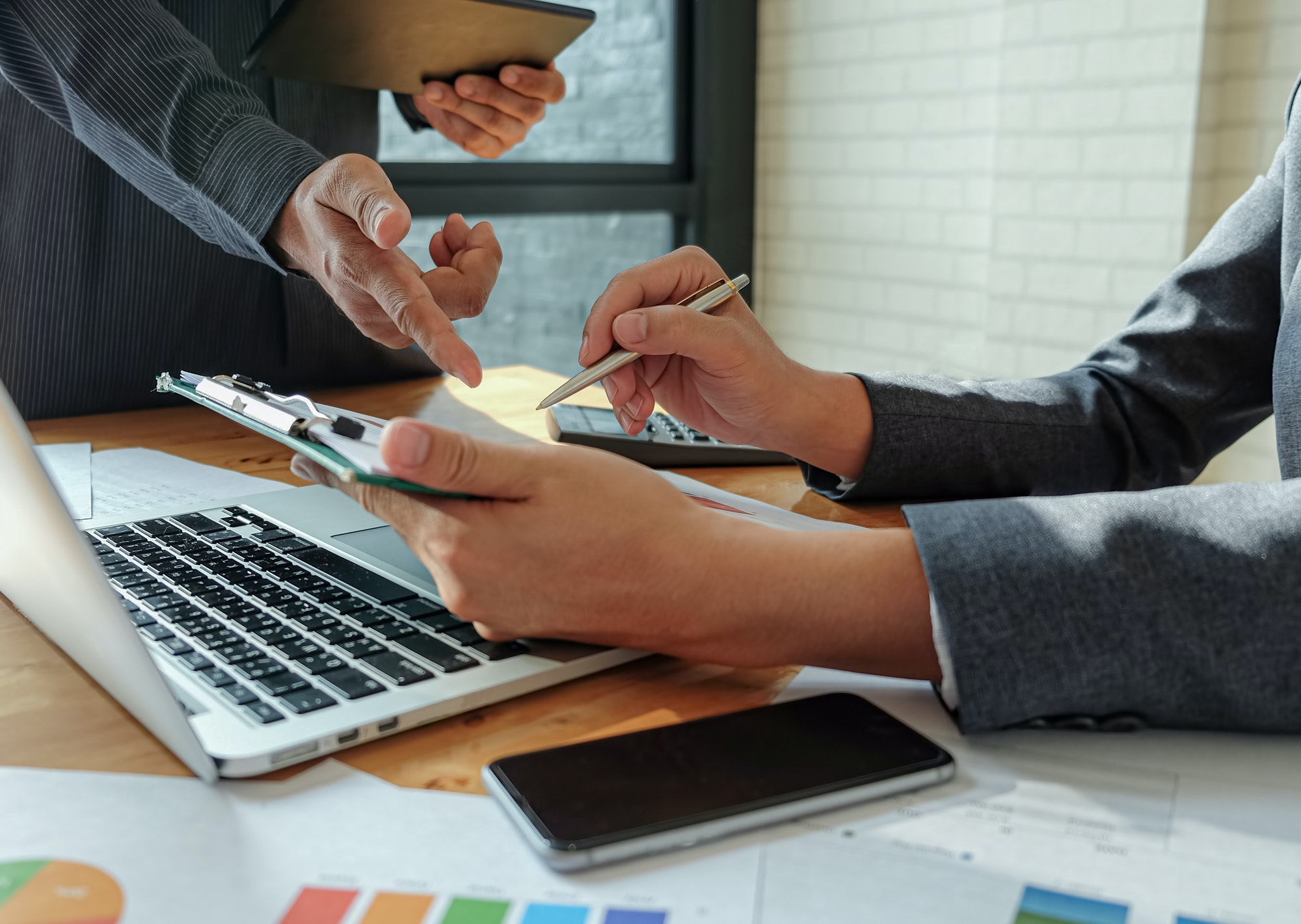 Management team work on tablet to summarize work to achieve organizational goals.